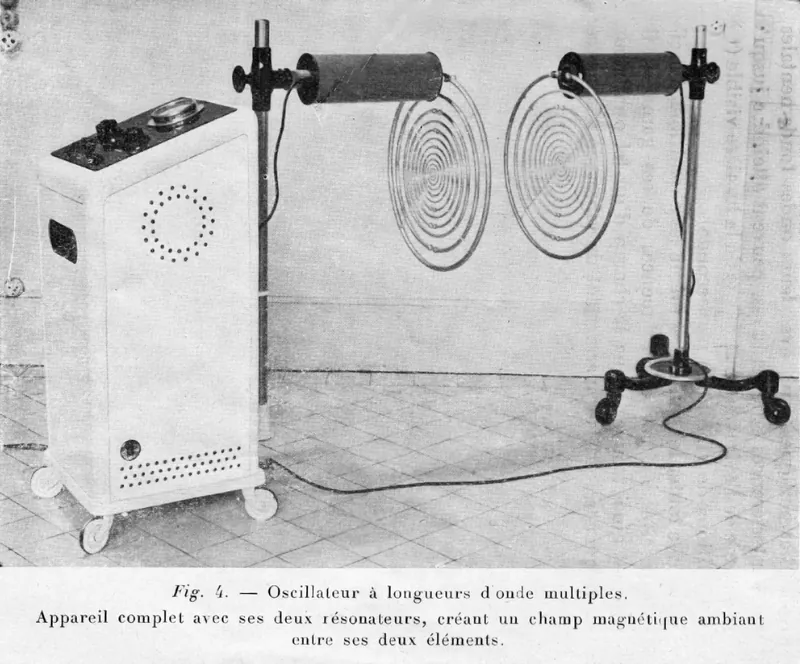 Lakhovsky's multiple wave oscillator in a 1937 photograph: a white cabinet generator on castors wired to two round coil resonators made of concentric rings, mounted on stands facing each other on a tiled floor